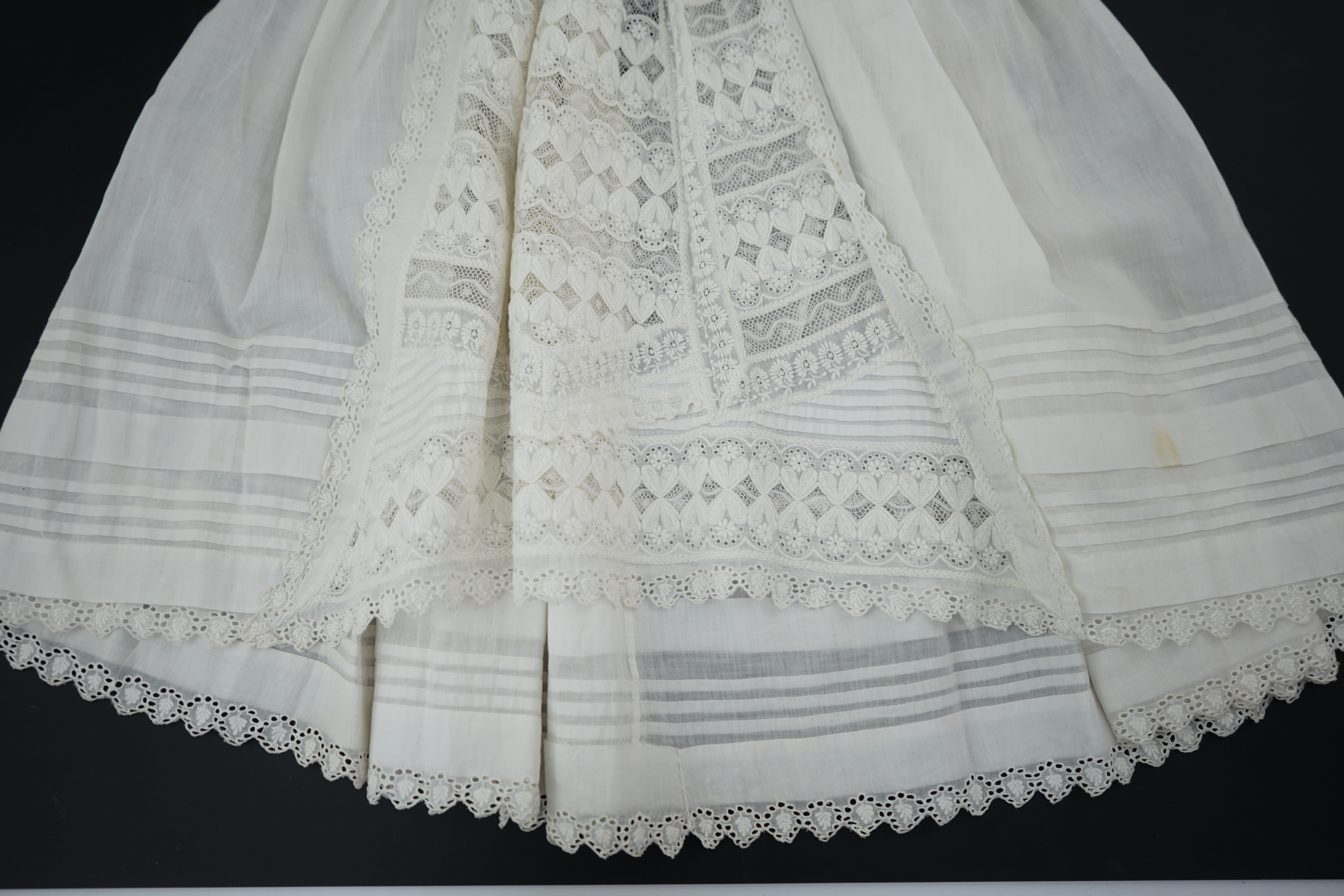 Two unusual 19th century intricately white worked children’s dresses, one hand worked with fine panels of white work, feather stitching and tucking, edged and inserted with hand made Valenciennes lace, the other worked i